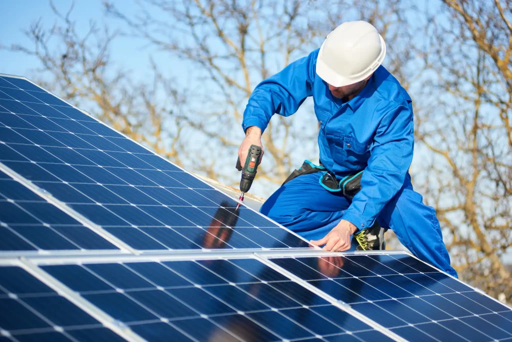 Man installing solar panels on roof