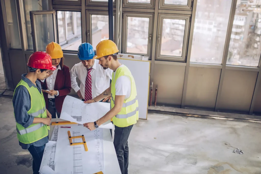 Workers discussing a project with blueprint